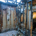 Burnt wooden walls house with charred roof burnt fire damaged interior details